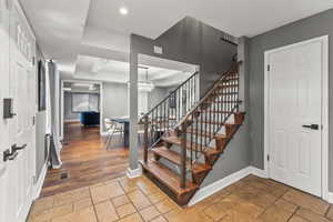 Stairs with stone tile floors, recessed lighting, baseboards, a chandelier, and visible vents