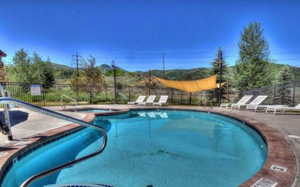 Community pool featuring a community hot tub and a patio