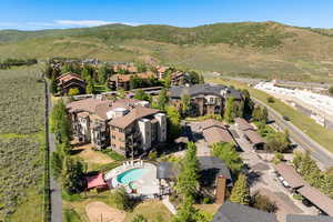 Aerial view of residential area featuring a pool and a mountainous background