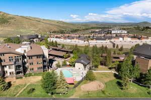 Aerial perspective of suburban area featuring a mountainous background and a pool area