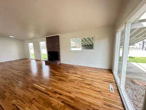 Unfurnished living room with wood finished floors and a fireplace