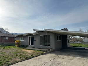 View of front of home featuring driveway and an attached carport
