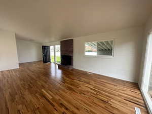 Unfurnished living room featuring wood finished floors and a fireplace