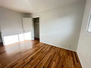 Unfurnished bedroom featuring a closet and wood finished floors