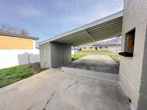 View of parking featuring a carport and driveway