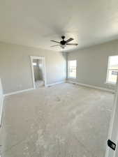 Unfurnished bedroom featuring a ceiling fan, a textured ceiling, and connected bathroom