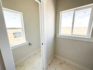 Bathroom featuring light marble finish floors and plenty of natural light