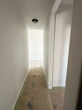 Hallway with baseboards and a textured ceiling