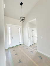 Foyer entrance with baseboards and lofted ceiling