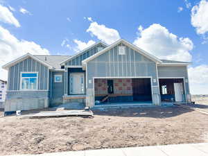 View of front of home featuring a garage, driveway, board and batten siding, and a shingled roof