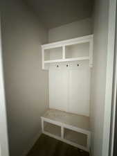 Mudroom featuring dark wood-type flooring and baseboards