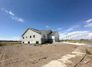 View of property exterior with board and batten siding, stone siding, driveway, and a garage