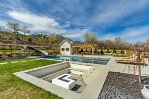 Outdoor pool with a mountain view, a pergola, a fire pit, a water slide, and a patio area