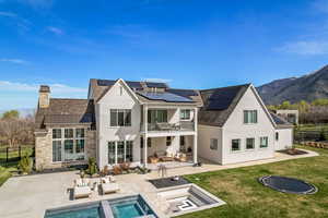 Rear view of property with a fenced in pool, an outdoor hangout area, a balcony, a patio area, and a lawn
