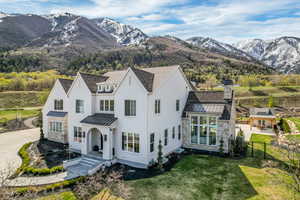 View of front of house with fence, a front lawn, a standing seam roof, stone siding, and metal roof