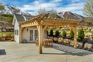 View of patio with fence, a pergola, french doors, and a mountain view
