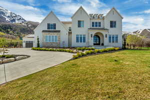 View of front of home with driveway, fence, a mountain view, a front yard, and stucco siding