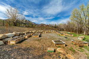 View of yard featuring fence and a vegetable garden