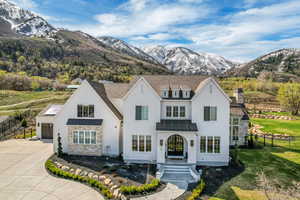 View of front facade featuring driveway, fence, a mountain view, metal roof, and a standing seam roof