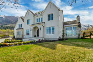 View of front of home with fence, a front yard, a standing seam roof, and a mountain view