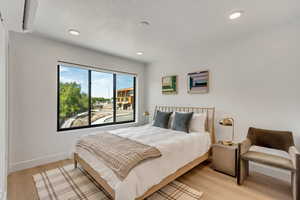 Bedroom featuring baseboards, recessed lighting, and light wood-style floors