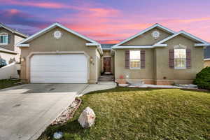 Ranch-style house featuring a garage, stucco siding, fence, a front lawn, and driveway