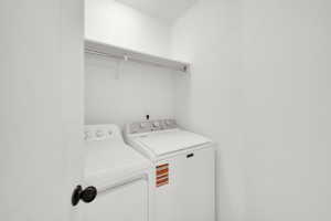 Clothes washing area featuring washer and dryer and laundry area