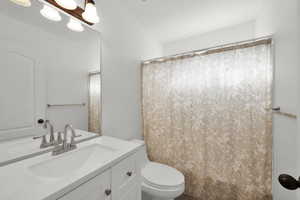 Bathroom featuring vanity, a shower with curtain, and toilet