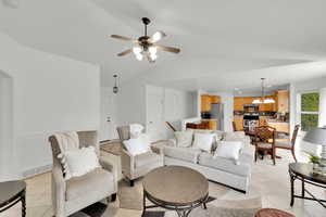 Living room with visible vents, light tile patterned flooring, a ceiling fan, and lofted ceiling