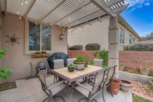 View of patio featuring outdoor dining space, fence, and a pergola