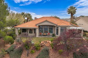 Rear view of property with a patio, stucco siding, and a tile roof