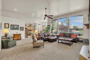 Carpeted living area with recessed lighting, a textured ceiling, and a ceiling fan