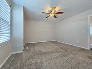 Spare room featuring baseboards, a ceiling fan, and carpet floors