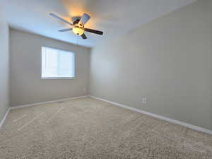 Unfurnished room featuring light colored carpet, ceiling fan, and baseboards