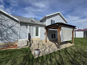 Rear view of property featuring a pergola, a lawn, entry steps, a patio area, and fence