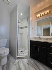 Bathroom with visible vents, toilet, a textured ceiling, a shower stall, and vanity