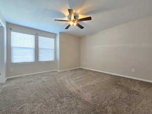 Carpeted spare room with baseboards, a textured ceiling, and ceiling fan