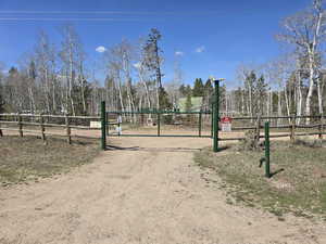 View of community with fence and dirt driveway