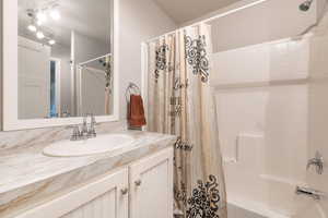 Bathroom with shower / bath combination with curtain and vanity
