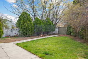 View of yard with an outbuilding, fence, and a storage shed