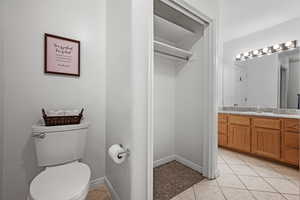 Bathroom with tile patterned flooring, vanity, baseboards, and toilet