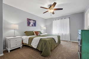 Bedroom with dark carpet, ceiling fan, and baseboards
