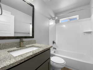 Full bath featuring bathing tub / shower combination, vanity, and toilet