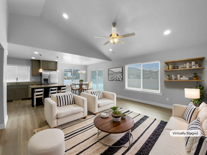 Living area with light wood-style floors, ceiling fan with notable chandelier, baseboards, and recessed lighting