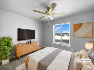 Bedroom with carpet floors, baseboards, and a ceiling fan