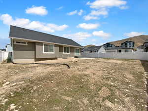 Rear view of house featuring a fenced backyard, a residential view, and stucco siding