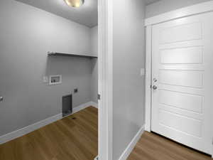 Washroom with laundry area, wood finished floors, washer hookup, hookup for an electric dryer, and baseboards