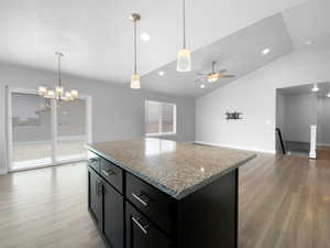 Kitchen with dark cabinetry, light wood-style floors, and plenty of natural light