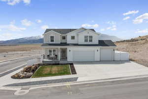 View of front facade featuring a porch, board and batten siding, a mountain view, and fence