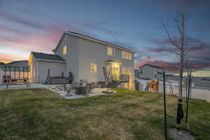 Rear view of house featuring a yard, stucco siding, a patio, fence, and a playground
